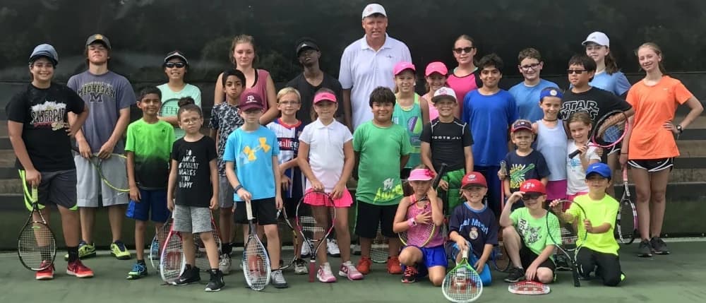 Summer campers with a coach on court at King's Court, 2017.