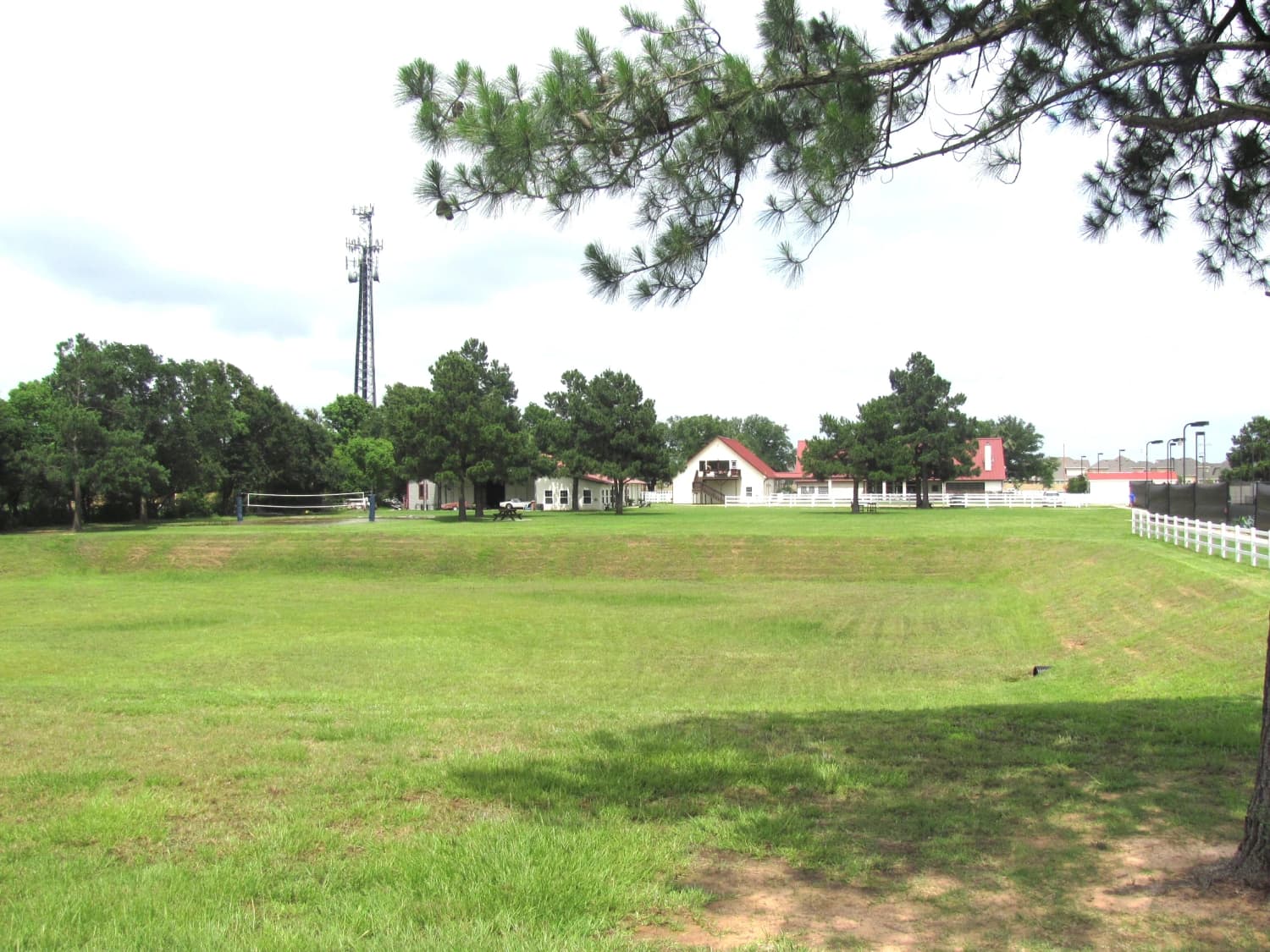 Huber Ranch: lawn, the white clubhouse with its red roof, floodlight masts at the right.